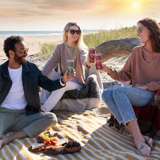 Three friends enjoying Jeng’s THC-infused beverages at the beach, relaxing together.