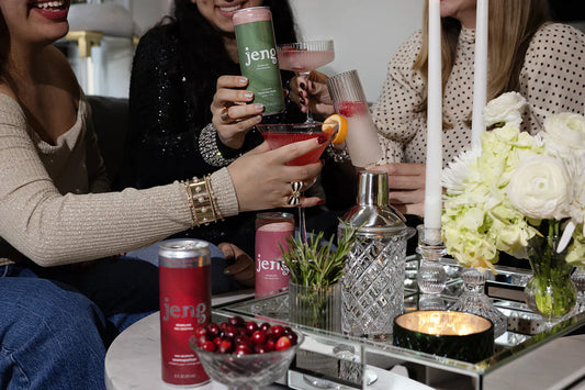  Friends toasting with Jeng sparkling cocktails in elegant glasses at a cozy gathering.