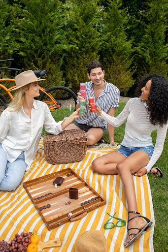 Three friends at a picnic enjoying Jeng’s alcohol-free, hemp-infused cocktails.
