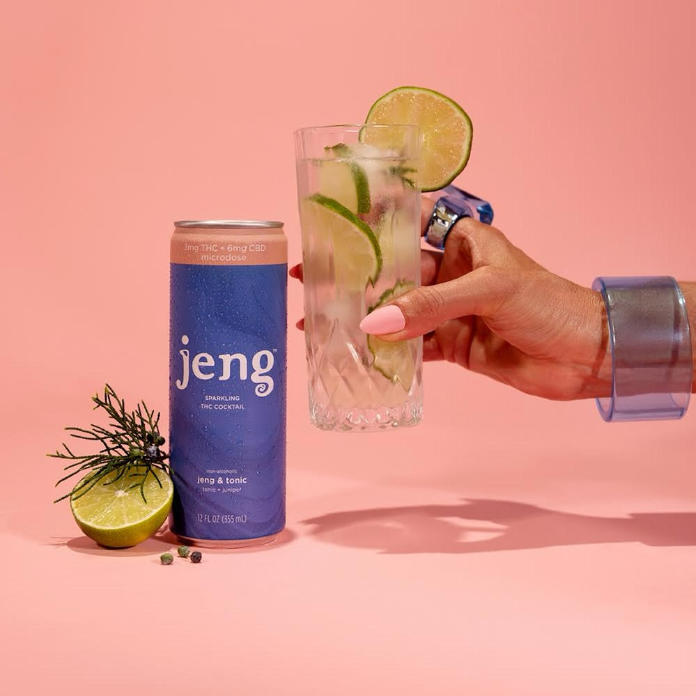 Jeng & Tonic THC-infused cocktail can beside a lime-garnished drink on a pink background.