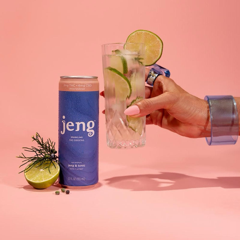 Jeng & Tonic THC-infused cocktail can beside a lime-garnished drink on a pink background.