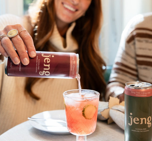 Woman pouring Jeng's THC-infused Rhubarb Cucumber Spritz into a chilled glass with Moscow Mule on the table.