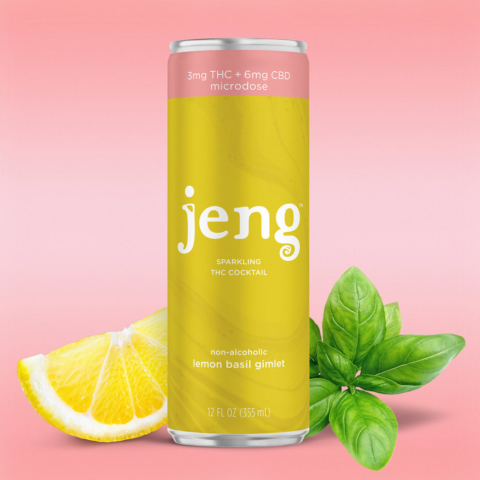 Jeng Lemon Basil Gimlet can with fresh basil leaves and lemon slices on a marble counter.
